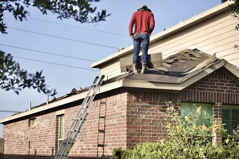 Professional roofer working on a residential roof in Larchmont